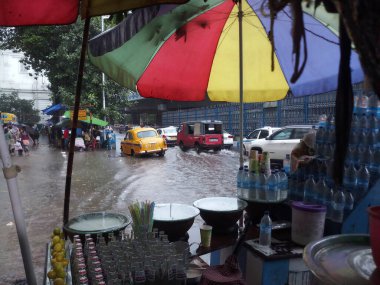 Kolkata, Batı Bengal, Hindistan - 16 Ağustos 2019: Arka planda muson yağmurları altında bir yol kenarı dükkânı ıslanıyor. Sarı taksi bekliyor. Kolkata 'nın yağışlı sezonu,