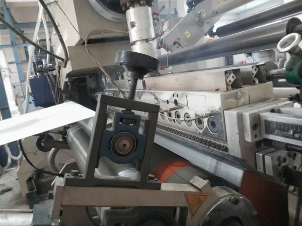 Kolkata, Batı Bengal, Hindistan - 7 Ocak 2019: Kağıt üzerinde kağıt bardak yapmak için polietilen, PE, kaplama için çalışan ekstrader ve paten,