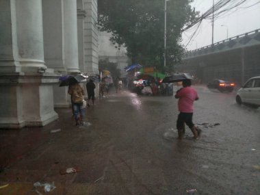 Kolkata, Batı Bengal, Hindistan - 16 Ağustos 2019: Hint müzesi yakınlarındaki su dolu patikada yürüyen yayalar. Kolkata 'da muson yağmurları,