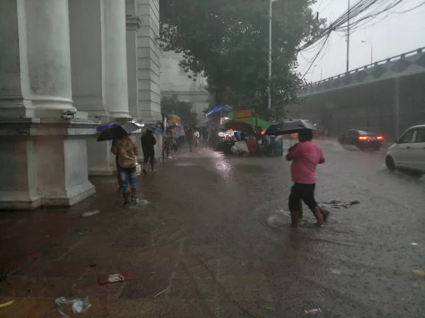 Kolkata, Batı Bengal, Hindistan - 16 Ağustos 2019: Hint müzesi yakınlarındaki su dolu patikada yürüyen yayalar. Kolkata 'da muson yağmurları,