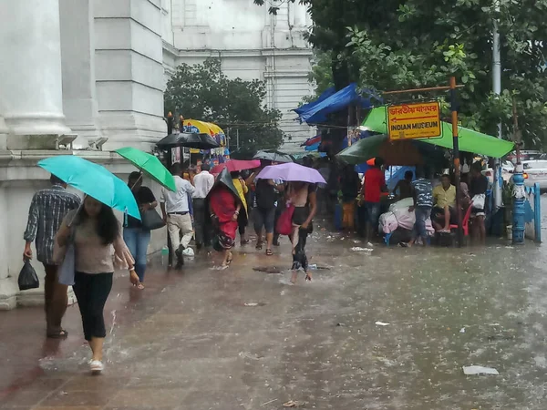 Kolkata, Batı Bengal, Hindistan - 16 Ağustos 2019: Hint müzesi yakınlarındaki su dolu patikada yürüyen yayalar. Kolkata 'da muson yağmurları,