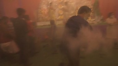 Kolkata, Hindistan - 13 Ekim 2021: Dhaakis dhaaks çalarken Tanrıça Durga 'nın önünde dans eden Hindu dindar dhunuchi naach. Kutsal duman tüm bölgeyi kaplamış..