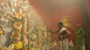 Kolkata, Hindistan -13 Ekim 2021: Hindu rahipler tanrıça Durga 'ya ghanta, chamor ve el yelpazesiyle tapıyorlar. Ashtami puja aarati - kutsal Durga Puja ritüeli - gece çekildi. 4K video.