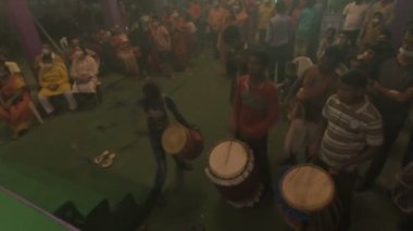Kolkata, Hindistan -13 Ekim 2021: Dhaakis dhaaks oynarken Hindu rahipler kabuklu veya shankha, chamor ve el vantilatörü ile tanrıça Durga 'ya tapıyorlar. Ashtami puja aarati - kutsal Durga Puja ritüeli.