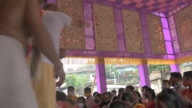 Howrah, Batı Bengal, Hindistan - 14 Ekim 2021: Hindu rahip shantir jol ya da shanti bari denilen kutsal suyu tanrıça Durga 'nın kutsamasını yaymak için yapılan bir ritüel olan pederlere atıyor..