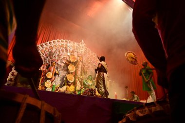 Howrah, Batı Bengal, Hindistan -13 Ekim 2021: Dhaakis dhaaks oynarken Hindu rahipler tanrıça Durga 'ya kabuk veya shankha ile tapıyorlar. Ashtami puja aarati - kutsal Durga Puja ritüeli.