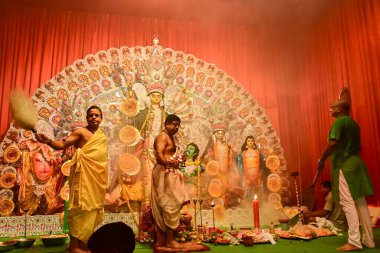 Howrah, Hindistan -13 Ekim 2021: Hindu Rahipler Tanrıça Durga 'ya tapıyorlar panchapradip, ghanta, chamor ve el fanı ile. Ashtami puja aarati - kutsal Durga Puja ritüeli - gece çekildi.