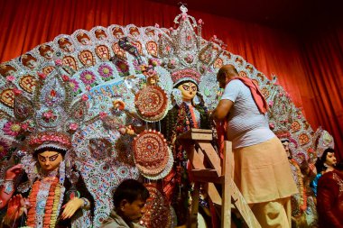 Howrah, Hindistan - 15 Ekim 2021: Hindu rahip Tanrıça Durga 'ya, Ashtami ve Nabami' nin kutsal kavşağı Sandhi Puja 'dan önce çelenk taktı..