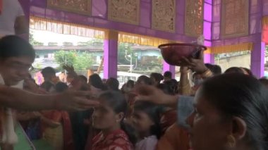 Howrah, Batı Bengal, Hindistan - 14 Ekim 2021: Hindu dindarları Tanrıça Durga 'ya itici güç sunuyorlar, tanrıçaya çiçeklerle tapınma ritüeli..