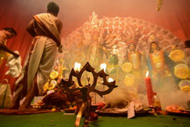 Howrah, Batı Bengal, Hindistan - 13 Ekim 2021: Tanrıça Durga kutsal panchapradip ile Hindu rahipler tarafından tapınılıyor, toprakta, ashtami puja sırasında puja pandalının içinde kutsal dumanla.