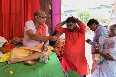 Howrah, Batı Bengal, Hindistan - 14 Ekim 2021: Hindu Purohit Charanomrito, kutsal su ve kutsanmışları tanrıça Durga 'ya ibadet etmeleri için tanrıça Durga' ya sundu..