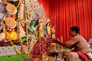 Howrah, Batı Bengal, Hindistan - 14 Ekim 2021: Hindu Purohit Sanskrit shlokas 'ın tanrıça Durga' ya itme hareketi, tanrıçaya çiçeklerle tapınma ritüeli.