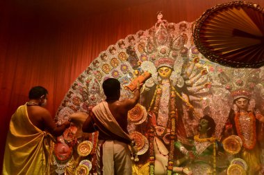 Howrah, Hindistan -13 Ekim 2021: Hindu Rahipler Tanrıça Durga 'ya Shari, ghanta, chamor ve el fanı ile tapıyorlar. Ashtami puja aarati - kutsal Durga Puja ritüeli - gece çekildi.