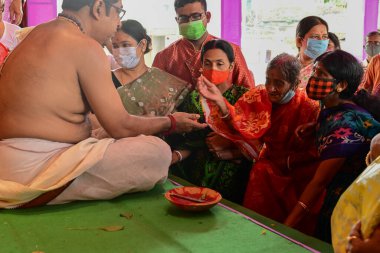Howrah, Batı Bengal, Hindistan - 14 Ekim 2021: Hindu Purohit, tanrıçaya tapınmak için tanrıça Durga 'ya yapılan ilahi ayin sırasında kutsanmıştır..