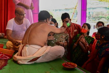 Howrah, Batı Bengal, Hindistan - 14 Ekim 2021: Hindu Purohit, Tanrıça Durga 'ya ibadet etmek için tanrıça Durga' ya itme sırasında dindarların alınlarına kutsal tilak takıyor..