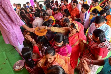 Howrah, Batı Bengal, Hindistan - 14 Ekim 2021: Hindu dindarlar Tanrıça Durga 'ya kakalamak için sepetin içine para koyuyorlar, tanrıçaya çiçeklerle ve zenginlik için parayla ibadet etme ritüeli..