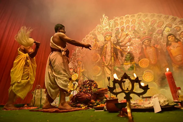 Howrah, Batı Bengal, Hindistan - 13 Ekim 2021: Tanrıça Durga kutsal panchapradip ile Hindu rahipler tarafından tapınılıyor, toprakta, ashtami puja sırasında puja pandalının içinde kutsal dumanla.