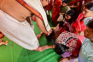 Howrah, Batı Bengal, Hindistan - 14 Ekim 2021: Hindu Purohit, tanrıçaya tapınmak için tanrıça Durga 'ya yapılan ilahi ayin sırasında kutsanmıştır..