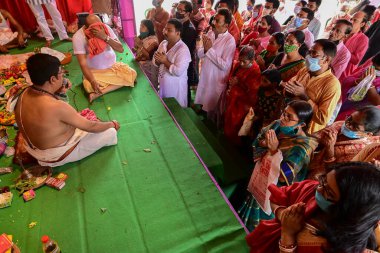 Howrah, Batı Bengal, Hindistan - 14 Ekim 2021 Hindu Purohit Hindu dindarlar için Sanskritçe shloka 'lar söyleyerek tanrıça Durga' ya itme ayini, çiçeklerle tanrıçaya tapınma ritüeli.