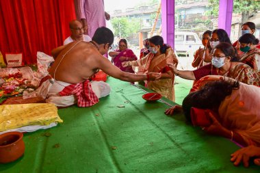 Howrah, Batı Bengal, Hindistan - 14 Ekim 2021: Hindu Purohit, tanrıçaya tapınmak için tanrıça Durga 'ya yapılan ilahi ayin sırasında kutsanmıştır..