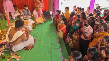 Howrah, Batı Bengal, Hindistan - 14 Ekim 2021 Hindu Purohit Hindu dindarlar için Sanskritçe shloka 'lar söyleyerek tanrıça Durga' ya itme ayini, çiçeklerle tanrıçaya tapınma ritüeli.