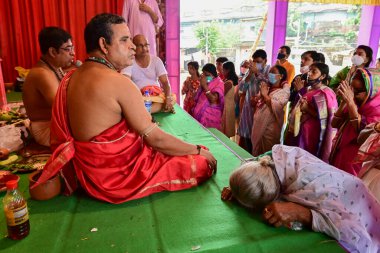 Howrah, West Bengal, India - 14th October 2021 : Senior aged Bengali widow worshipping Goddess Durga during pushpanjali to Goddess Durga, Ashtami puja of Durga Puja festival.