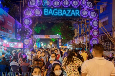 Kolkata, Batı Bengal, Hindistan - 12 Ekim 2021: UNESCO 'nun soyut kültürel mirası Bagbazar Durga Puja için büyük bir hoşgeldin kapısı. Gece vakti ünlü Puja pandalını ziyaret etmek için acele edenler.
