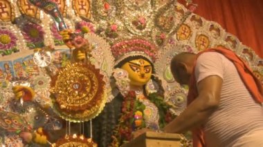 Howrah, Hindistan - 15 Ekim 2021: Hindu rahip Tanrıça Durga 'ya, Ashtami ve Nabami' nin kutsal kavşağı Sandhi Puja 'dan önce çelenk taktı..