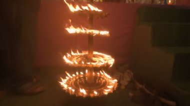 Howrah, India- October 15th, 2021 : Holy 108 lamps are lit during sondhipujo aarti by Hindu purohits. Goddess Durga is being worshipped at night, juncture of Ashtami and Nabami. Durga puja ritual.