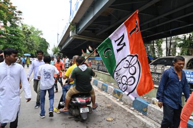Kolkata, West Bengal, India - 21st July 2022 : All India Trinamool Congress Party, AITC or TMC, at Ekushe July, Shadid Dibas, Martyrs day rally. Party supporters arriving on motorbike with party flag.
