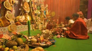 Howrah, India- October 15th, 2021 : Hindu purohits worshipping Goddess Durga for Sandhi Puja, the sacred juncture of Ashtami, eighth day and Nabami, nineth day, as Hindu ritual for praying to Goddess.