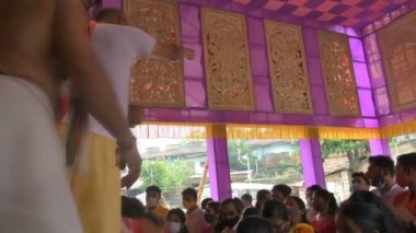 Howrah, Batı Bengal, Hindistan - 14 Ekim 2021: Hindu rahip shantir jol ya da shanti bari denilen kutsal suyu tanrıça Durga 'nın kutsamasını yaymak için yapılan bir ritüel olan pederlere atıyor..