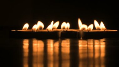 Very low angle view of Diwali diyas or candles. Deepawali lights at night. Dark background stock footage.