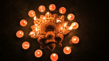 Top view of diwali candles or diya put in circle. Deepawali lights at night. Dark background stock footage.