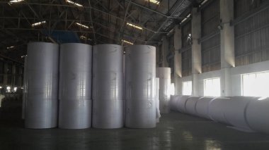 Kolkata, West Bengal, India - 6th May 2021 : White Paper rolls are being manufactured in a paper manufacturing plant. Indian paper industry is growing.