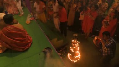 Howrah, India- October 15th, 2021 : Hindu devotees praying to Goddess Durga with folded hands on Sandhi Puja, the sacred juncture of Ashtami and Nabami, as ritual. Holy 18 lamps are lit.