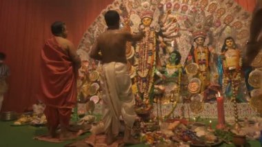 Howrah, India- October 15th, 2021 : Hindu purohits worshipping Goddess Durga with holy candle on Sandhi Puja, the sacred juncture of Ashtami, eighth day and Nabami, nineth day, as Hindu ritual.