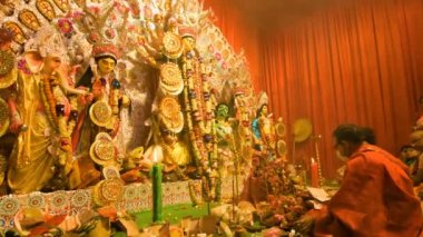 Howrah, India- October 15th, 2021 : Hindu purohits worshipping Goddess Durga for Sandhi Puja, the sacred juncture of Ashtami, eighth day and Nabami, nineth day, as Hindu ritual for praying to Goddess.