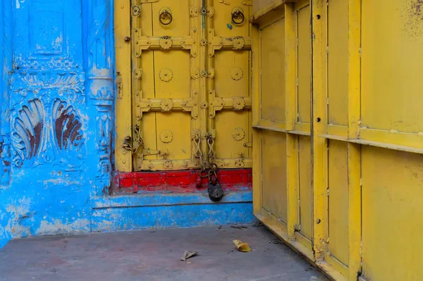 Traditional yellow wooden door and blue coloured house of Jodhpur city, Rajsthan, India. Historically, Hindu Brahmins used to paint their houses in blue for being upper caste, the tradition follows.