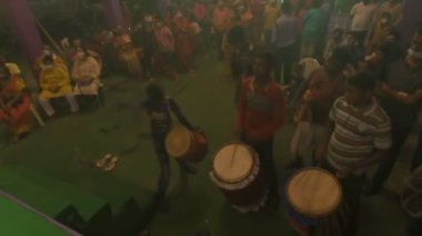 Kolkata, Hindistan -13 Ekim 2021: Dhaakis dhaaks oynarken Hindu rahipler kabuklu veya shankha, chamor ve el vantilatörü ile tanrıça Durga 'ya tapıyorlar. Ashtami puja aarati - kutsal Durga Puja ritüeli.