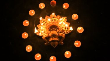 Top view of diwali candles or diya put in circle. Deepawali lights at night. Dark background stock footage.