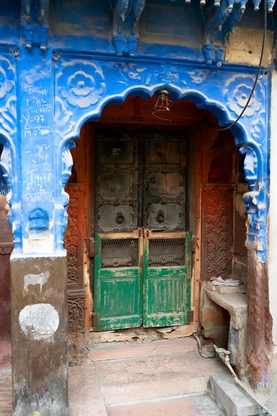 Traditional wooden door and blue coloured house of Jodhpur city, Rajsthan, India. Historically, Hindu Brahmins used to paint their houses in blue for being upper caste, the tradition follows.