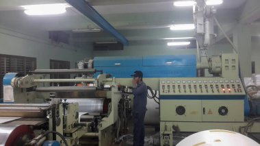 Kolkata, Batı Bengal, Hindistan - 16 Şubat 2017: Ekstrüder ve silindirler kağıt kaplama, kağıt bardaklar için PE.