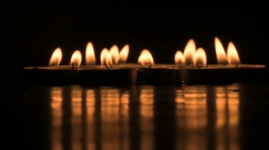 Very low angle view of Diwali diyas or candles. Deepawali lights at night. Dark background stock footage.