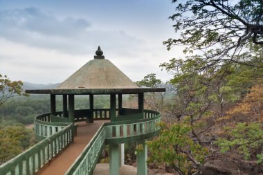 Viewpoint. Forest seen from viewpoint with cloudy sky, distant mountains in the background and forest in the foreground. Karnataka, India.