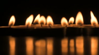 Very low angle view of Diwali diyas or candles. Deepawali lights at night. Dark background stock footage.