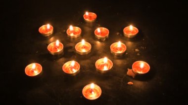 Top view of diwali candles or diya put in circle. Deepawali lights at night. Dark background stock footage.