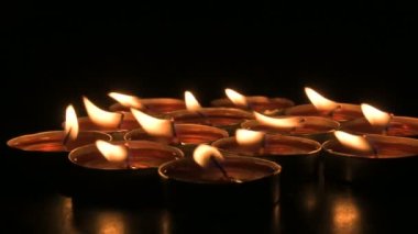 Very low angle view of Diwali diyas or candles. Deepawali lights at night. Dark background stock footage.