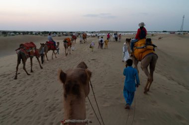 Thar Çölü, Rajassthan, Hindistan - 15 Ekim 2019: Thar Çölü 'nün kum tepelerinde deveye binen turistler. Deve sürmek burayı ziyaret eden tüm turistler arasında favori bir etkinliktir.,