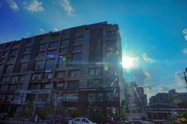 Kolkata, Batı Bengal, Hindistan - 20 Temmuz 2019: Kolkata şehir manzarası, binaların modern mimarisi, bulutların arasından fışkıran güneş ışınları, arka planda mavi gökyüzü.